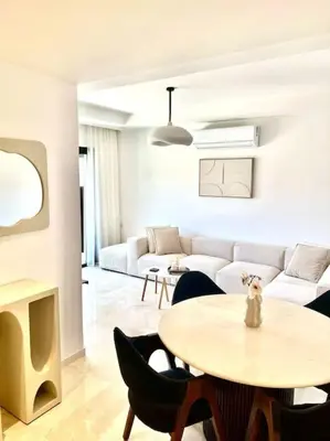 a living room with a table and a couch at Appartement NOVA Noria in Marrakech