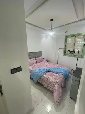 a bedroom with a bed in a white room at Luxury Apartment in Marrakesh two in Marrakech