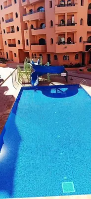 a large blue swimming pool in front of a building at M32 Cosy Loft in Marrakech