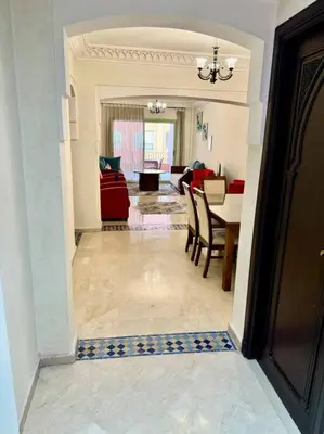 a hallway with a dining room and a living room at Beautiful Hivernage Apartment with Pool & Balcony, Near Attractions in Marrakech