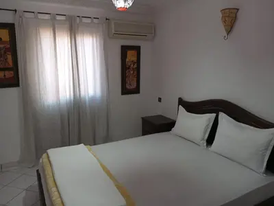 a bedroom with a white bed and a window at Riad Selma résidence face Médina avec Piscines in Marrakech