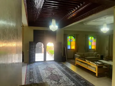 a living room with a couch and stained glass windows at Splendide villa de charme à Marrakech in Marrakech