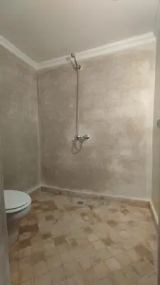 a bathroom with a toilet and a tiled floor at Splendide villa de charme à Marrakech in Marrakech