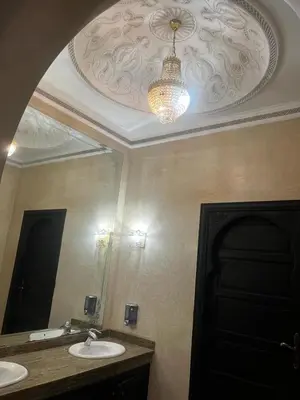 a bathroom with two sinks and a mirror and a chandelier at Splendide villa de charme à Marrakech in Marrakech