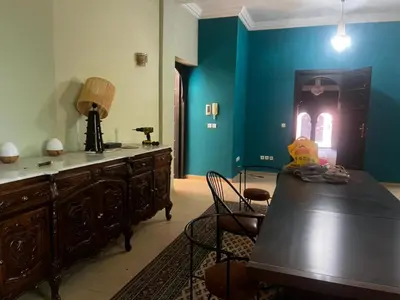 a dining room with a table and a blue wall at Splendide villa de charme à Marrakech in Marrakech