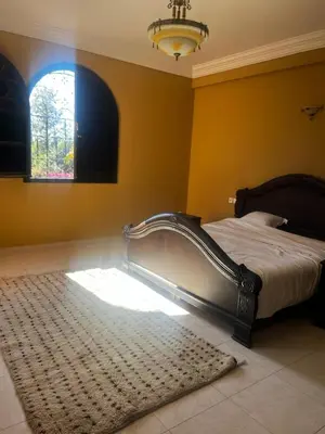 a bedroom with a bed and a window and a rug at Splendide villa de charme à Marrakech in Marrakech