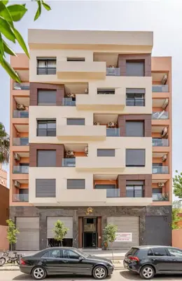 two cars parked in front of a building at Charmant appartement en plein centre ville gueliz in Marrakech