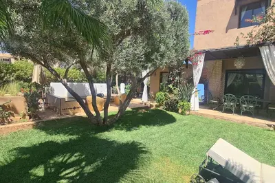 a yard with a tree and a house at Villa LES LAURIERS, 4 suites, piscine privée, petit déjeuner compris in Marrakech