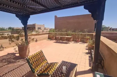 a patio with chairs and tables and a building at Villa LES LAURIERS, 4 suites, piscine privée, petit déjeuner compris in Marrakech