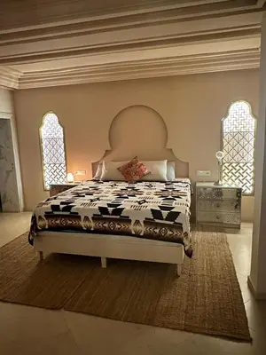 a bedroom with a bed in a room with two windows at Villa Shambhala in Marrakech