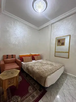 a bedroom with a bed and a couch and a table at DarYOUSSEF 68 in Marrakech