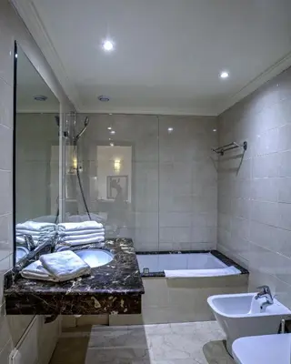 a bathroom with a tub and a sink and a bath tub at Palm Appart Hôtel Marrakech in Marrakech