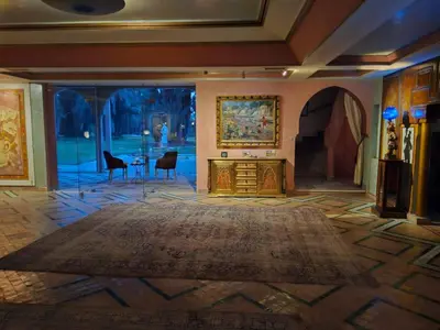 a living room with a table and a large rug at Palais Oussoud in Sidi Yahia az Zaʼer