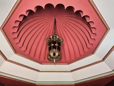 a room with a red ceiling with a chandelier at Palais Oussoud in Sidi Yahia az Zaʼer