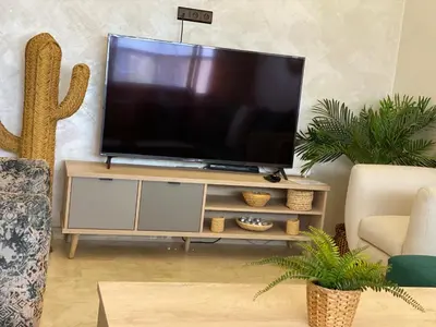 a flat screen tv sitting on a stand in a living room at apparte 2 chambres luxe en face la gare gueliz in Marrakech