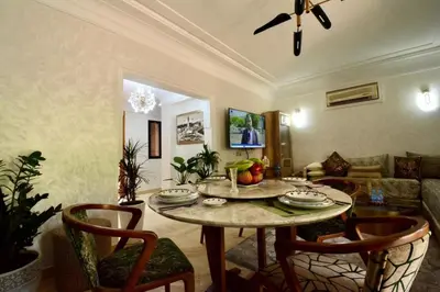 a living room with a table and chairs at Modern Garden-Level Apartment with Pool & Jacuzzi in Marrakech