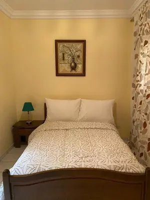 a bed in a bedroom with a picture on the wall at Riad butterfly Marrakech in Marrakech