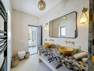 a bathroom with two sinks and a mirror at Riad Azrak in Marrakech