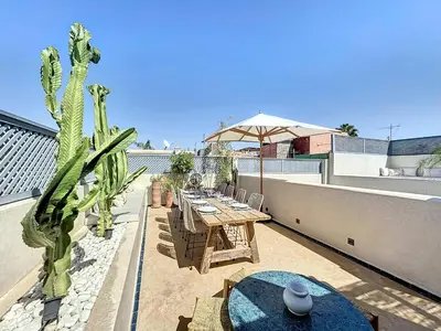 a patio with a table and a cactus on a roof at Riad Azrak in Marrakech