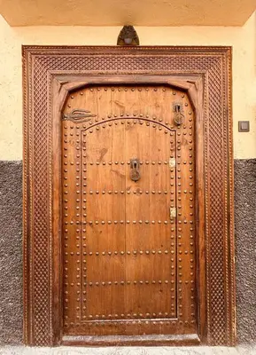 a wooden door on a building with ajar at Riad Azrak in Marrakech
