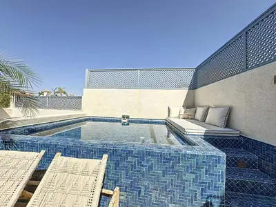 a swimming pool with two chairs and a couch at Riad Azrak in Marrakech
