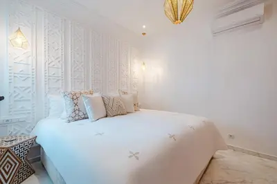 a white bedroom with a large white bed with pillows at Free People Riad and Spa in Marrakech