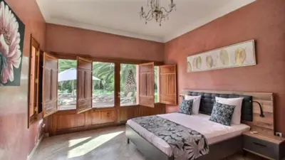 a bedroom with a bed in a room with windows at Villa Dauphin in Marrakech