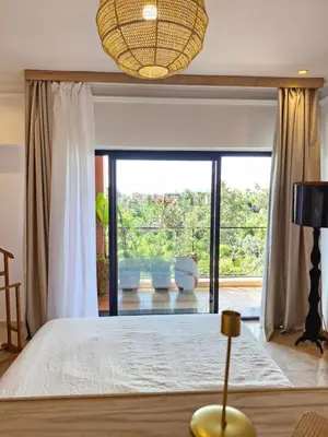 a bedroom with a bed and a large window at Luxueux Duplex rooftop en plein cœur de Majorelle in Marrakech