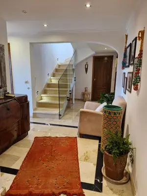a living room with a staircase and a rug at Luxueux Duplex rooftop en plein cœur de Majorelle in Marrakech