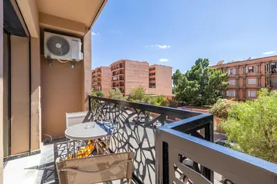 a balcony with a table and chairs on a building at Luxurious City Apartment in Marrakech