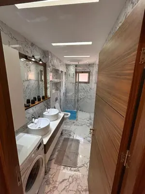 a bathroom with a toilet and two sinks in it at Bel Appartement Hivernage-Gueliz 2 chambres in Marrakech