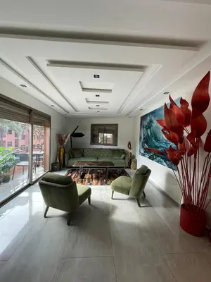 a living room with two chairs and a bed at Bel Appartement Hivernage-Gueliz 2 chambres in Marrakech