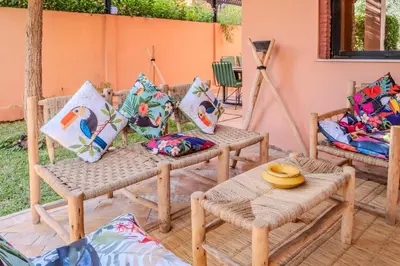 a patio with a table and chairs and pillows at Luxury Villa with Pool, Garden & Gated Security in Marrakech