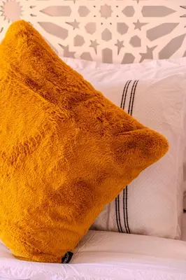 a yellow pillow sitting on top of a bed at Luxury Villa with Pool, Garden & Gated Security in Marrakech