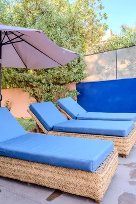 two wicker chairs and an umbrella on a patio at Luxury Villa with Pool, Garden & Gated Security in Marrakech