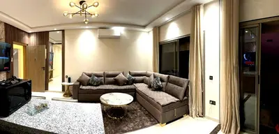 a living room with a couch and a table at Appartement luxueux, cosy & confortable in Marrakech