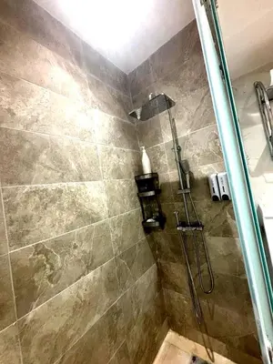 a bathroom with a shower with a glass door at Appartement luxueux, cosy & confortable in Marrakech