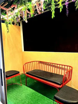 a bench and two chairs in front of a wall at Appartement luxueux, cosy & confortable in Marrakech