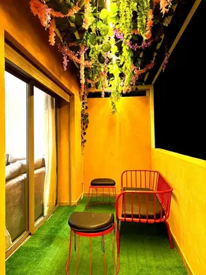 a room with two chairs and flowers hanging from a ceiling at Appartement luxueux, cosy & confortable in Marrakech