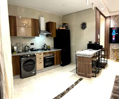a kitchen with a stove and a dishwasher at Appartement luxueux, cosy & confortable in Marrakech