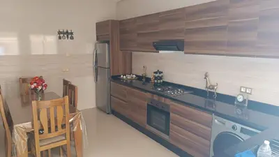 a kitchen with wooden cabinets and a stove top oven at Chez bousfyha 2 in Marrakech