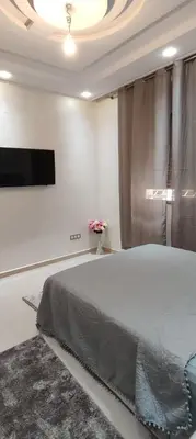 a bedroom with a bed and a flat screen tv at Chez bousfyha 2 in Marrakech