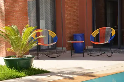 two chairs and a plant in front of a building at Atlas Royale Marrakech in Marrakech