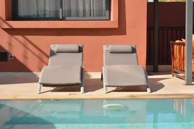 two chairs sitting next to a swimming pool at Atlas Royale Marrakech in Marrakech