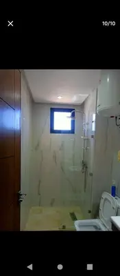 a bathroom with a glass shower with a toilet at Magnifique appartement in Marrakech