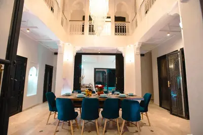 a dining room with a table and blue chairs at Villa oasis private pool secure complex in Marrakech