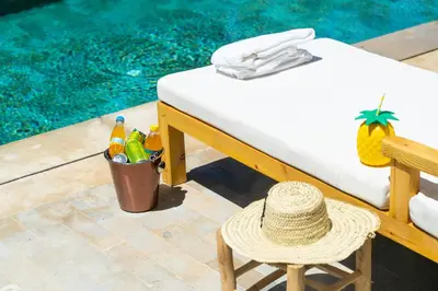 a straw hat sitting on a chair next to a pool at Villa oasis private pool secure complex in Marrakech
