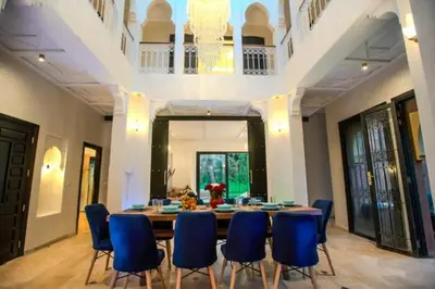 a dining room with a table and blue chairs at Villa oasis private pool secure complex in Marrakech