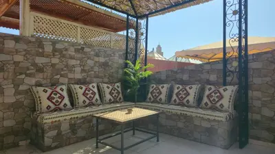 a patio with a bench and a table at Riad Miralezia in Marrakech