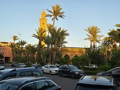 a parking lot with cars parked in front of a building at Riad Miralezia in Marrakech